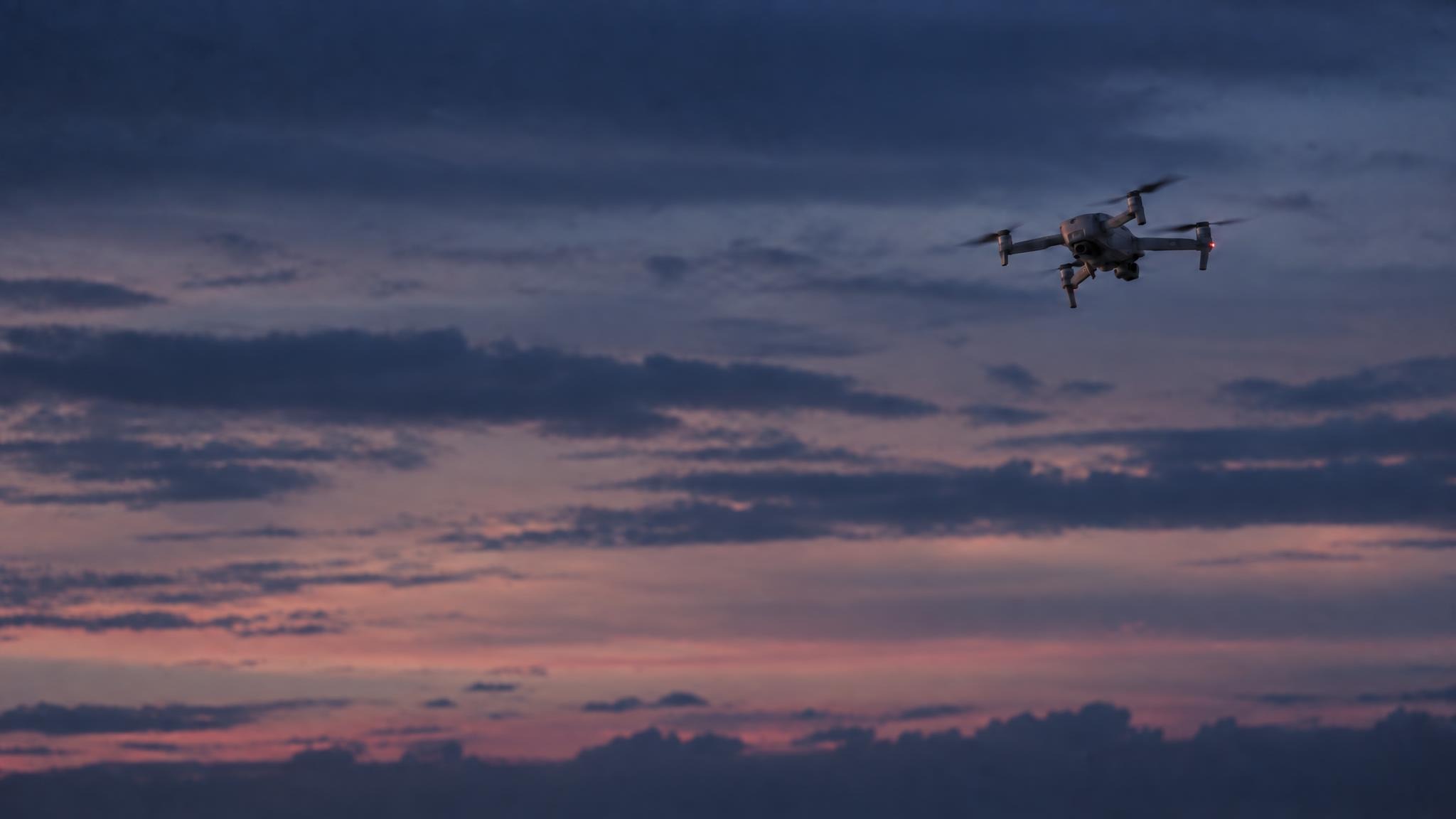 A Kepel aircraft in flight at dusk, low angle against a dark sky, cool rim light, no text