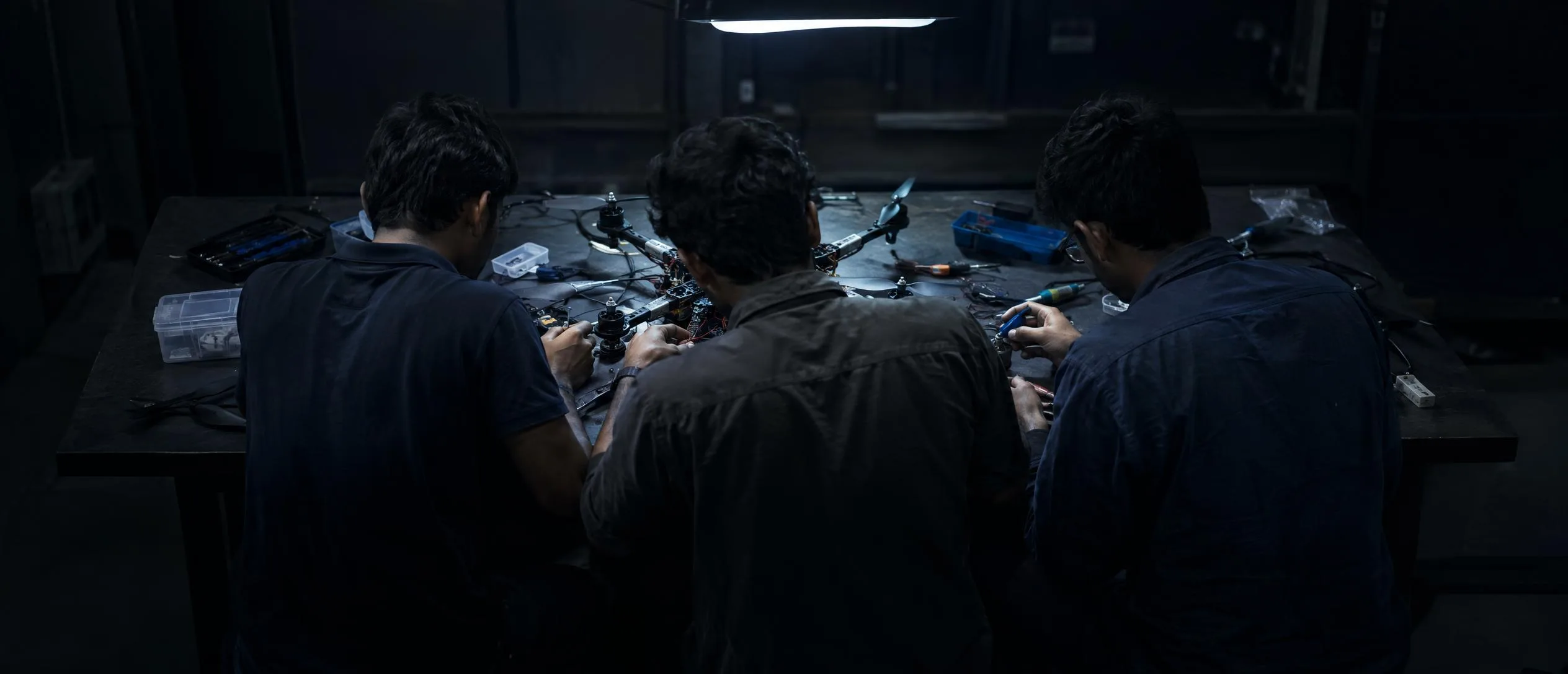 Engineers assembling an airframe in the Kepel workshop, practical light, shallow depth of field